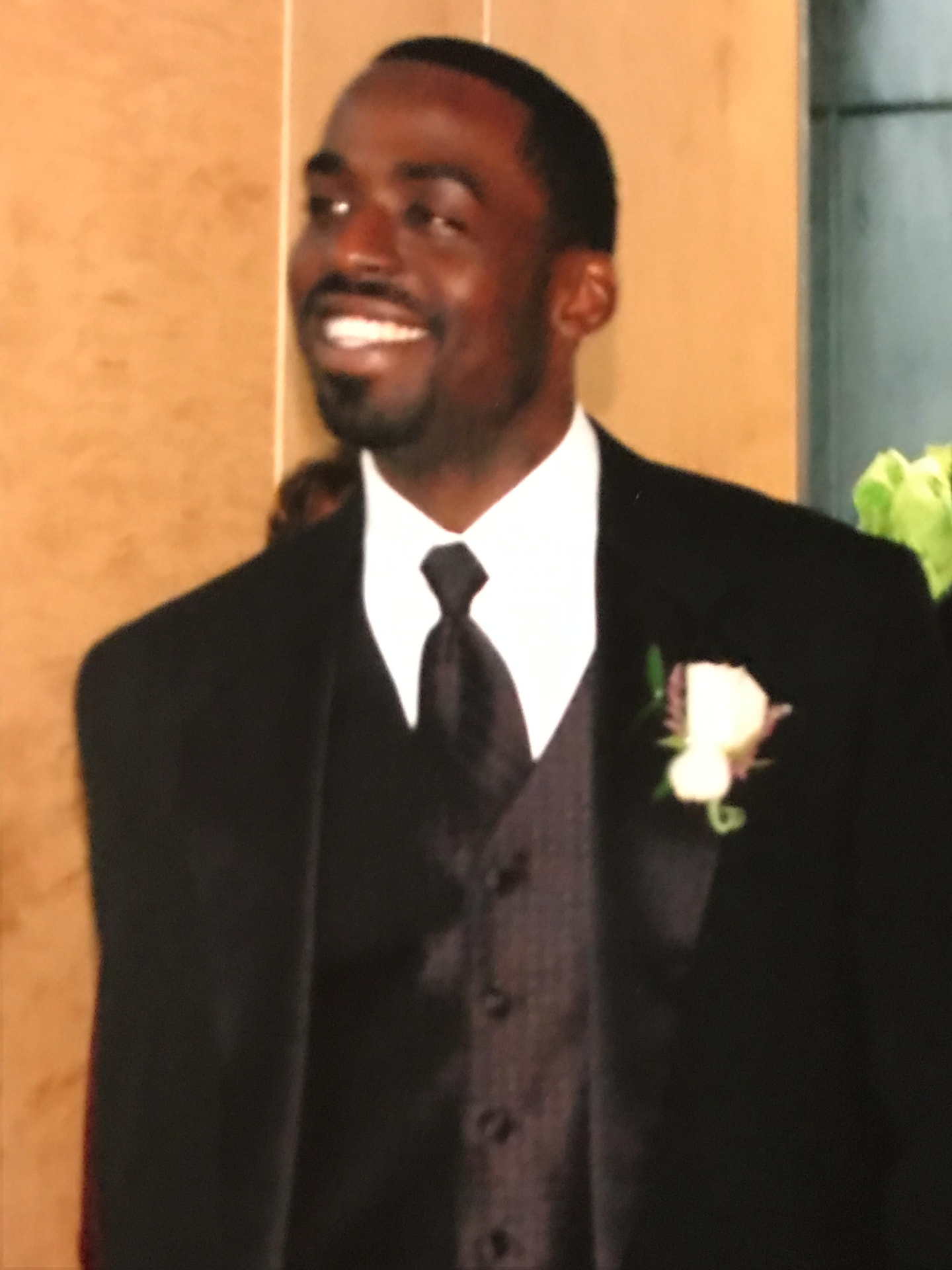 Tripoli smiling in a tuxedo at a wedding