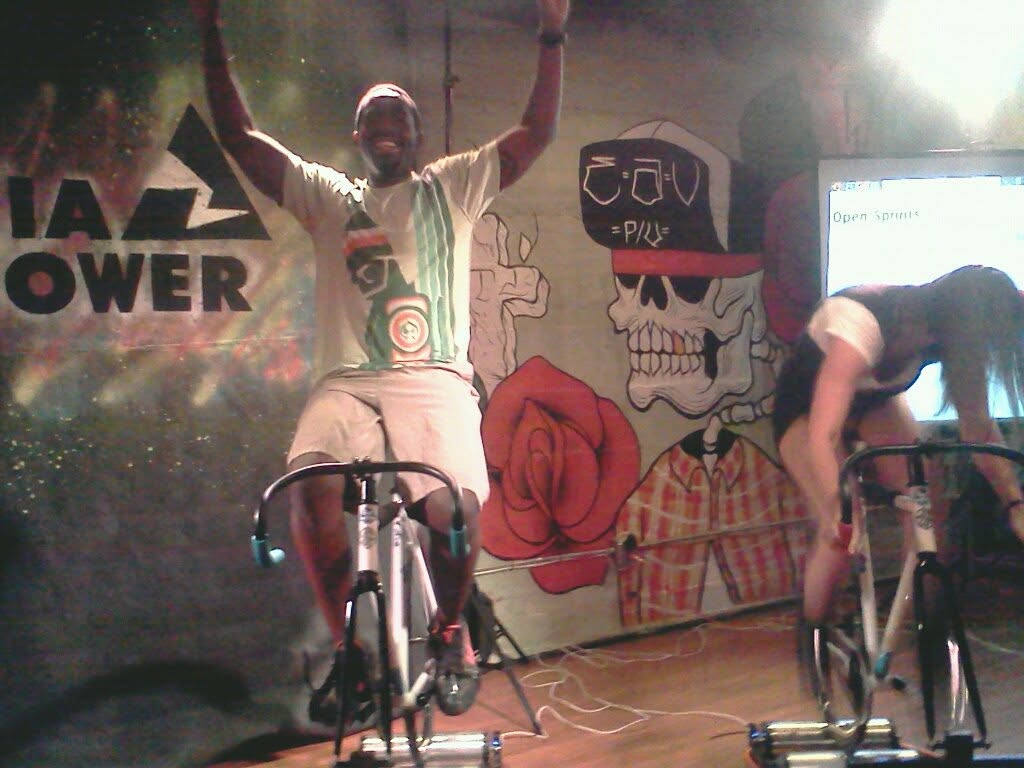 Tripoli riding a spin bike in front of mural art